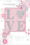 This anniversary card is a gentle ode to enduring romance, as if crafted for a couple slipping away to a favourite Fitzrovia café to celebrate another year together. At the centre, the word LOVE appears in raised, softly shimmering letters, with a delicate scattering of glitter giving a silvery glow along each curve. The letter O is transformed into a heart, rendered in a more densely textured silver that gleams a little brighter, becoming the visual and tactile anchor of the design. Surrounding this focal point, clouds of tender blossoms unfold in shades of blush, mauve, and pastel pink, their edges softened as though painted in watercolour and allowed to gently bleed into a background of warm white and pale grey. Fine, flowing lines sketch stems and tendrils that wind across the card like climbing plants along Fitzrovia's mews houses. Subtle flourishes-tiny petals caught mid-tumble, looping swirls, and faint butterflies-add a sense of movement and whimsy, reminiscent of a light breeze carrying the scent of flowers down a quiet side street off Tottenham Court Road. The inscriptions On Our Anniversary and I love you today and always are written in an elegant, flowing script, standing out clearly but never shouting, like a whispered promise between partners. Everything about the card-the gentle colour story, the silvery accents, the layered textures-creates a feeling of intimacy and quiet celebration. It feels like a keepsake designed to sit beside a vase of fresh anniversary flowers in a Fitzrovia home, marking the shared journey of two people with grace, warmth, and a touch of sparkle.